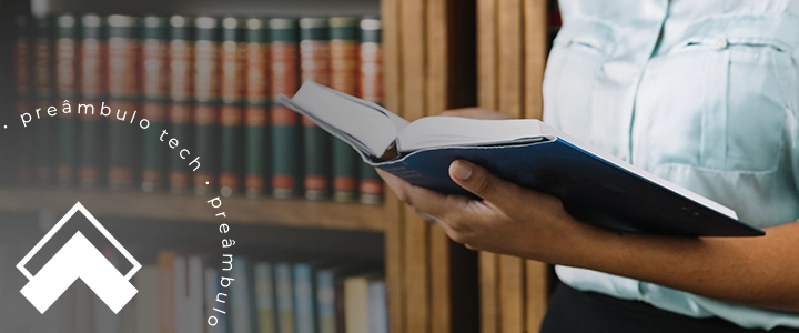 Advogado lendo livros para advogados em biblioteca jurídica, com foco em gestão e desenvolvimento profissional