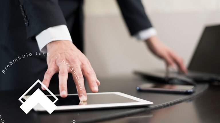 Advogado utilizando tablet e laptop em mesa de trabalho, representando a gestão de escritório com sistemas jurídicos e software jurídico.
