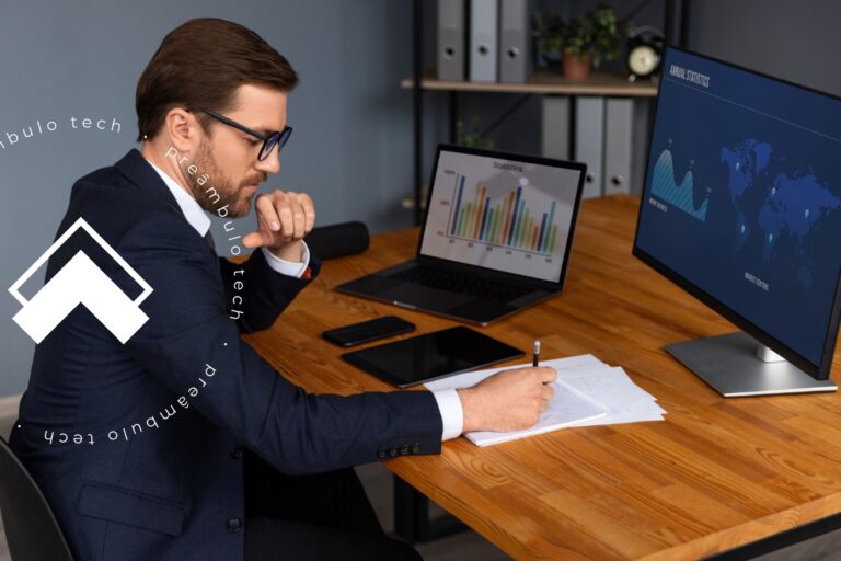 Advogado sentado à mesa na frente de um computador enquanto faz a análise de um relatório estratégico.