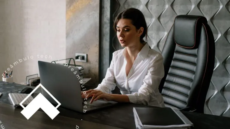 Advogada sentada à mesa do escritório, analisando tela de notebook, enquanto considera as tendências relacionadas ao uso de IA no setor jurídico.